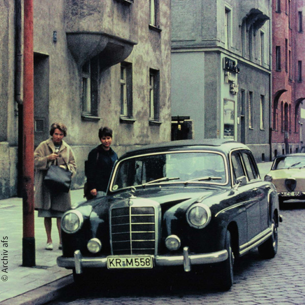 ein schwarzer Mercedes Benz 220 S steht am Straßenrand