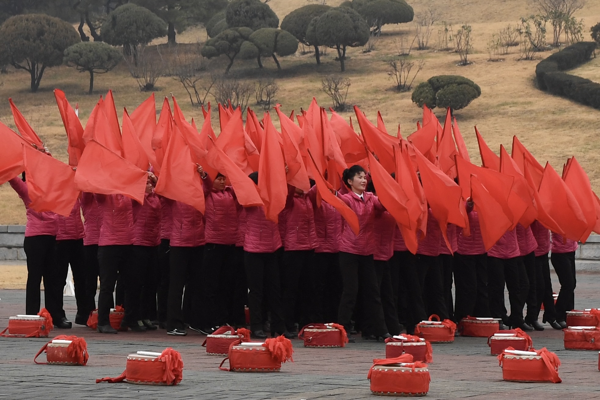  Ein Kopf lugt aus einem roten Fahnenmeer hervor. das Kollektiv steht ueber dem Individuum   