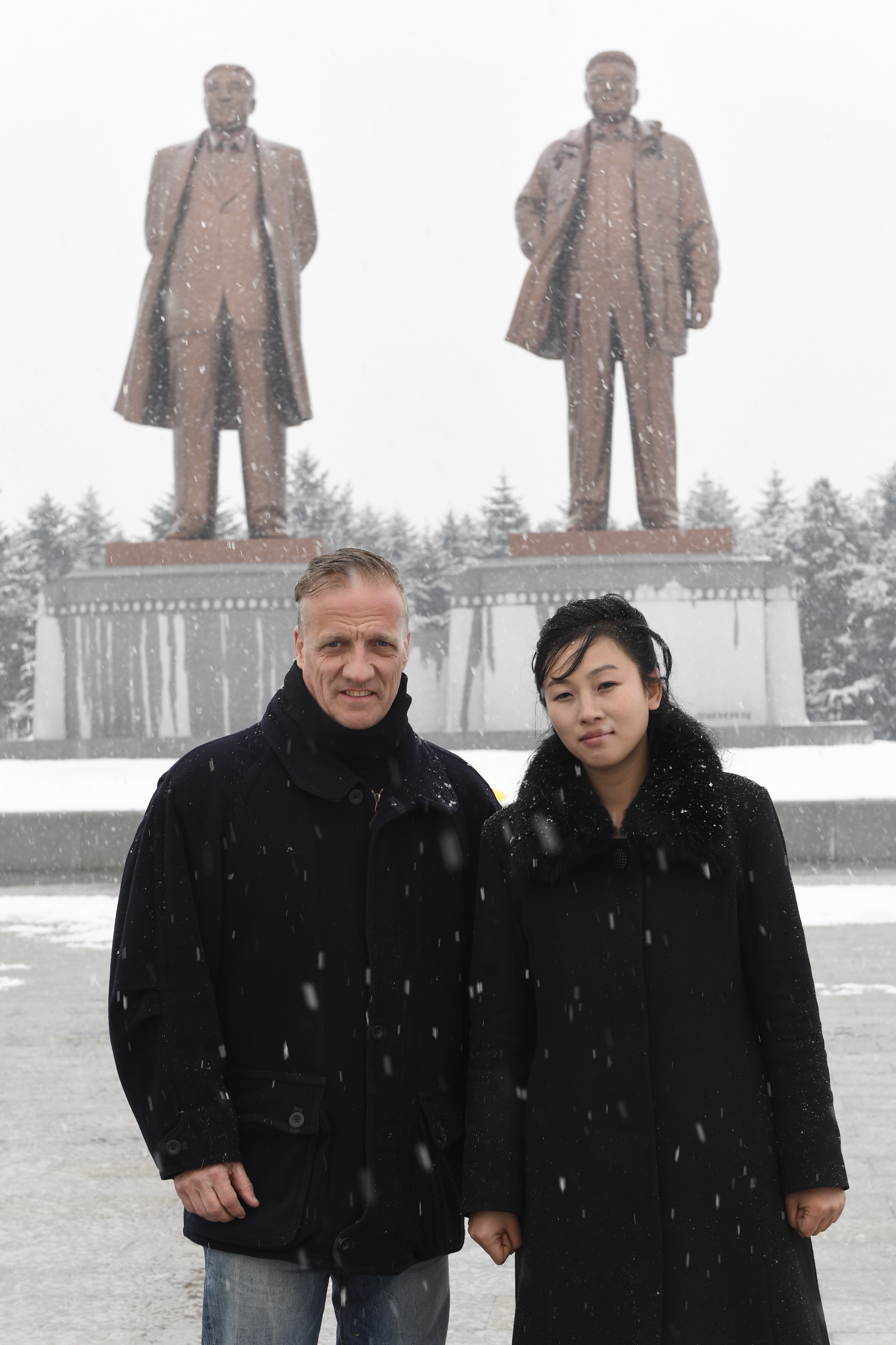 Der Autor mit Reiseleiterin in der &raquo;Stadt des Eisens&laquo;, Chongjin, unter den auch im Winter stets wachsamen Blicken des Staatsgr&uuml;nders und seines Sohnes
