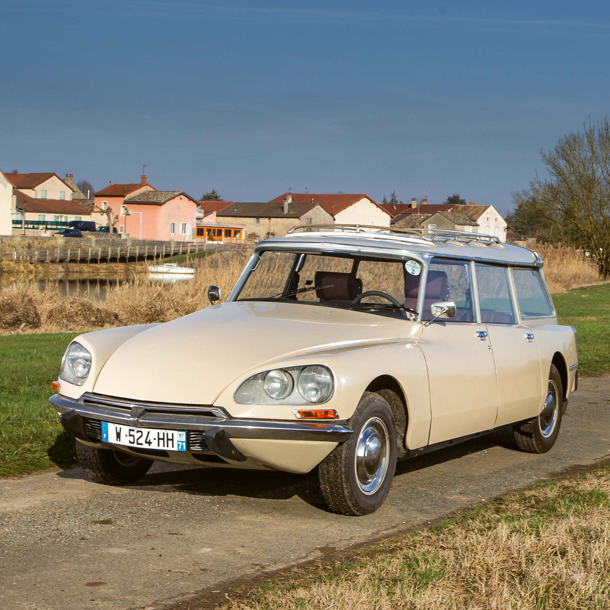 ein beigefarbener Citroën der Baureihe D steht auf einem asphaltiertem Weg