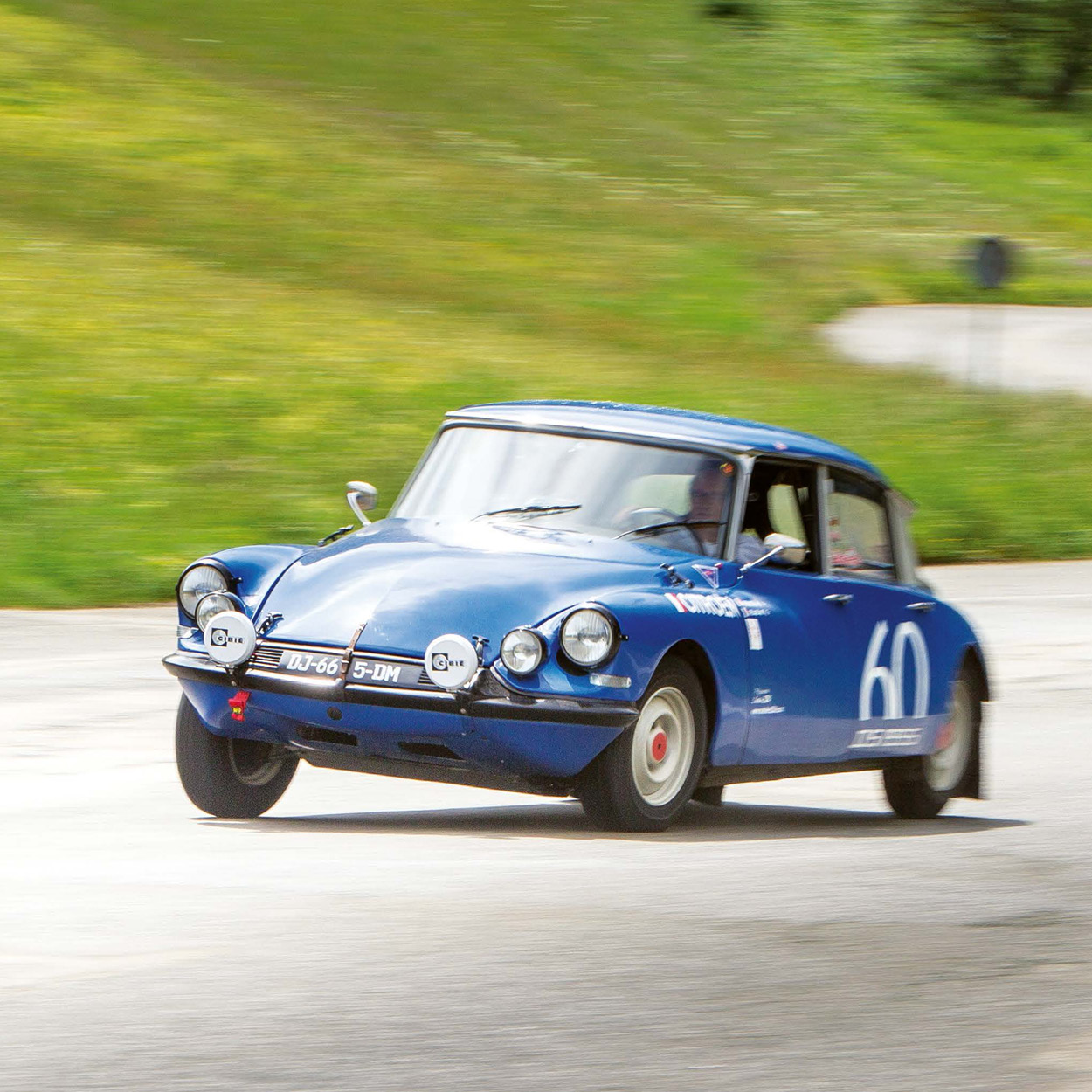 ein blauer Citroën DS fährt bei einer Rallye in eine Kurve